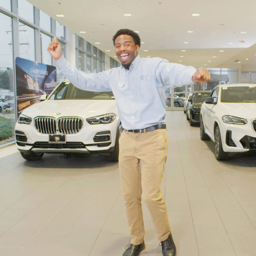 Man dancing in an auto showroom